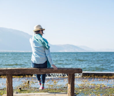 Rear view of peaceful woman sitting on a wooden bench